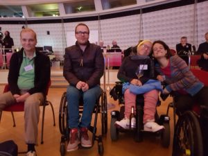 Es sind 4 Personen auf dem Bild zu sehen, welche sich gut verstehen, und den Programm lauschen.